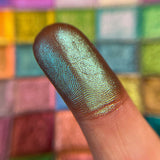 Close up finger swatch on fair skin tone of Viridian Deep Iridescent Multichrome Eyeshadow