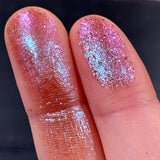 Close up finger swatches on fair skin tone of Abrasion Glitter Multichrome Eyeshadow
