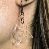 Acrylic Clionadh symbol earrings being worn